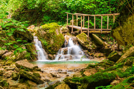 Waterfall, small lake and bridge in the ravine Chudo-Krasotka in summer day, Sochi, Russiaの写真素材