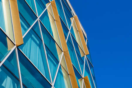 Glass facade of modern urban building on the background of clear sky, Saint Petersburg, Russiaの写真素材