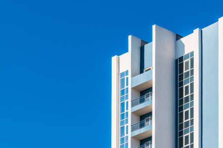 Low angle view of a corner of the urban apartment building on the background of clear sky, Sochi, Russiaの写真素材