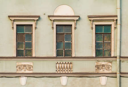 Three windows in a row on the facade of the urban historic building front view, Saint Petersburg,...