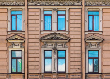 Several windows in a row on the facade of the urban historic building front view, Saint Petersburg,...