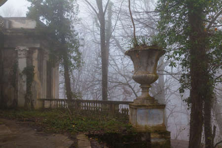 Vase and avant-corps of the abandoned building of the former restaurant on the top of Mount Akhun in dense fog, Sochi, Russiaの写真素材