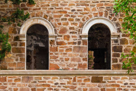 Two window gaps on the stone facade of the abandoned old mansion called Dacha Kvitko, Sochi, Russiaの写真素材