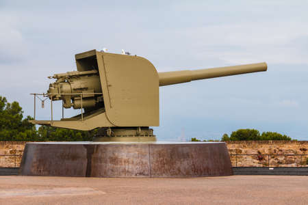 The cannon standing on the wall of the Montjuic Castle on a background of sky in overcast day closeup, Barcelona, Spainのeditorial素材