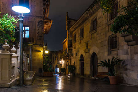 Barcelona, Catalonia, Spain - November 17, 2018: Beautiful night view of an illuminated street and buildings in the open-air Poble Espanyol architectural museumのeditorial素材