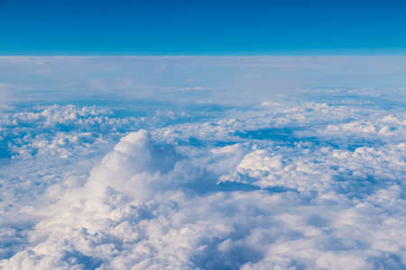 View from the porthole of airplane of a beautiful cloudscape of stratocumulus cloudsの写真素材