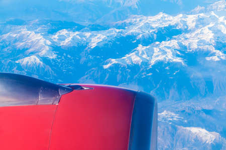 The turbine of the airplane above a mountains closeup, view from the portholeの写真素材