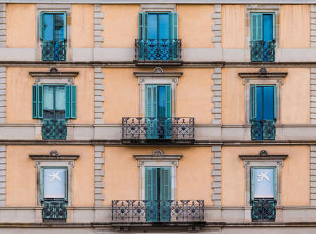 Several windows and balconies in a row on the facade of the urban historic building front view, Barcelona, Catalonia, Spainのeditorial素材