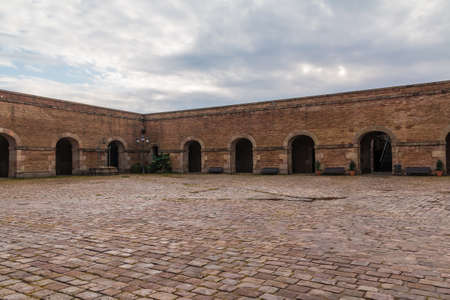 Barcelona, Catalonia, Spain - November 16, 2018: The courtyard of the Montjuic Castle with pavement, stone walls and arches in cloudy dayのeditorial素材