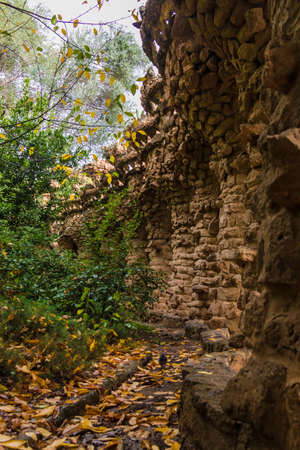 Barcelona, Catalonia, Spain - November 18, 2018: Beautiful view of the stone viaduct and lush vegetation in the Park Guell in overcast autumn dayのeditorial素材