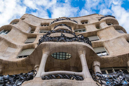 Barcelona, Catalonia, Spain - November 19, 2018: Worm's-eye view of Casa Mila on the background of cloudy sky. The building designed by Antonio Gaudi in the years 1906-1910.のeditorial素材