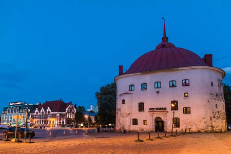 Vyborg, Leningrad Oblast, Russia - September 12, 2018: Beautiful view of the illuminated Market Square and the Round Tower at twilightのeditorial素材