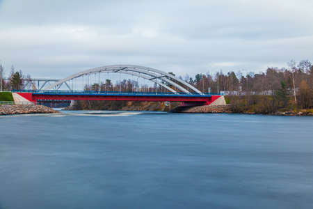 Long-exposure view of the Vuoksi River and the Vuoksi River Bridge in cloudy autumn day, Losevo, Leningrad Oblast, Russiaの写真素材