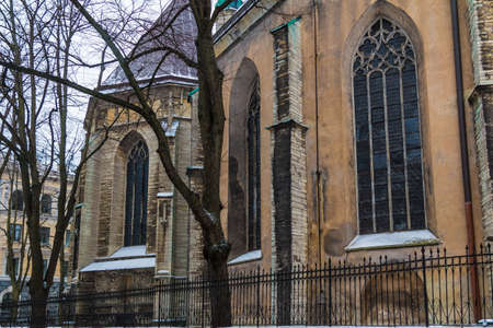 The yard, the fence and the facade of the Saint Olaf's Church in overcast winter day, Tallinn Old Town, Estoniaの写真素材