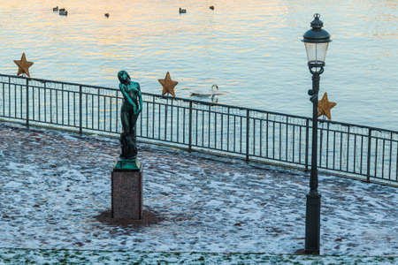 Stockholm, Sweden - December 26, 2018: The sculpture Fog by swedish sculptor Wilhelm Mauritz Gustaf "Gusten" Lindberg and a streetlight in the Stromparterren Park on the Helgeandsholmen Island in winter dayのeditorial素材