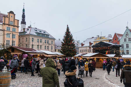 Tallinn, Estonia - December 25, 2018: Panoramic view of the Town Hall Square in the Tallinn Old Town with stalls and a crowd of walking people in overcast holiday winter dayのeditorial素材