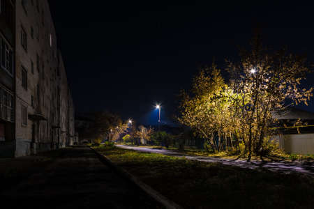 Beautiful perspective view of the illuminated Druzhby Street in autumn at night, Kurgan, Russiaの写真素材