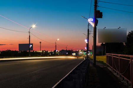 Beautiful perspective view of the illuminated viaduct on the Constitution Avenue at twilight, Kurgan, Russiaの写真素材