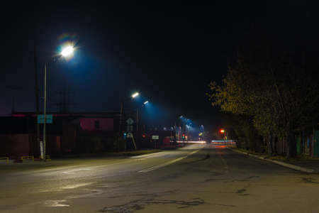 Beautiful perspective view of the illuminated Bazhova Street in autumn at night, Kurgan, Russiaの写真素材