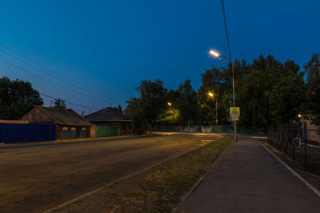 Perspective view of the illuminated Bazhova Street at twilight in summer, Kurgan, Russiaの写真素材