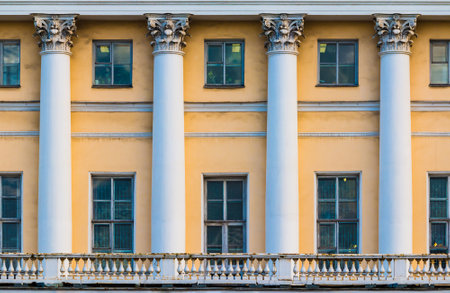 Columns and many windows in a row on the facade of the urban historic apartment building front view, Saint Petersburg, Russiaの写真素材