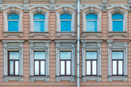 Many windows in a row on the facade of the urban historic apartment building front view, Saint Petersburg, Russiaの写真素材
