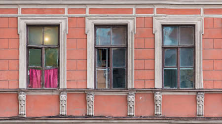 Three windows in a row on the facade of the urban historic apartment building front view, Saint...