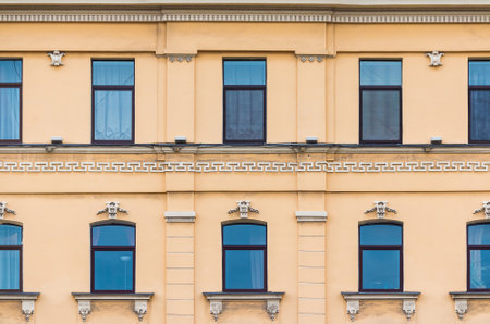 Many windows in a row on the facade of the urban historic apartment building front view, Saint Petersburg, Russiaの写真素材