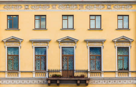 Balcony and many windows in a row on the facade of the urban historic apartment building front view, Saint Petersburg, Russiaの写真素材