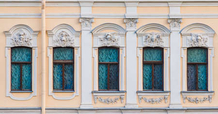 Several windows in a row on the facade of the urban historic apartment building front view, Saint Petersburg, Russiaの写真素材