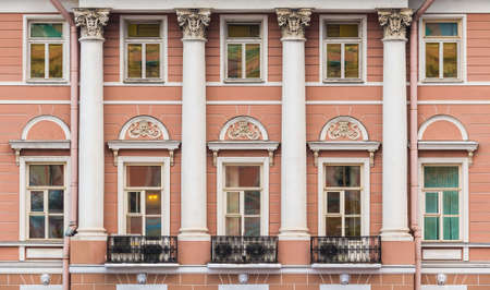 Columns and many windows in a row on the facade of the urban historic apartment building front view, Saint Petersburg, Russiaの写真素材