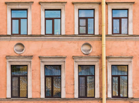 Several windows in a row on the facade of the urban historic apartment building front view, Saint Petersburg, Russiaの写真素材