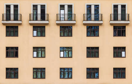 Balconies and many windows in a row on the facade of the modern urban apartment building front view, Krasnaya Polyana, Sochi, Krasnodar Krai, Russiaの写真素材