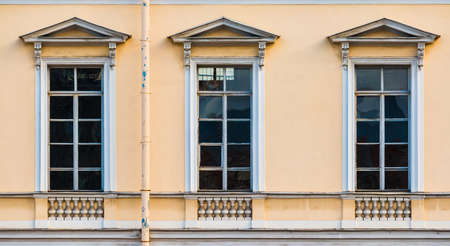 Three windows in a row on the facade of the urban historic apartment building front view, Saint Petersburg, Russiaの写真素材