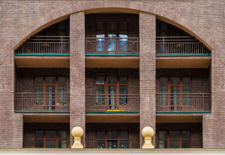 Many balconies and windows in a row on the facade of the modern urban apartment building front view, Krasnaya Polyana, Sochi, Krasnodar Krai, Russiaの写真素材
