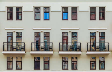 Several balconies and many windows in a row on the facade of the modern urban apartment building front view, Krasnaya Polyana, Sochi, Krasnodar Krai, Russiaの写真素材