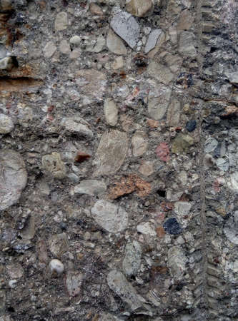 Ruined old concrete fence with the addition of stone and broken granite.の写真素材