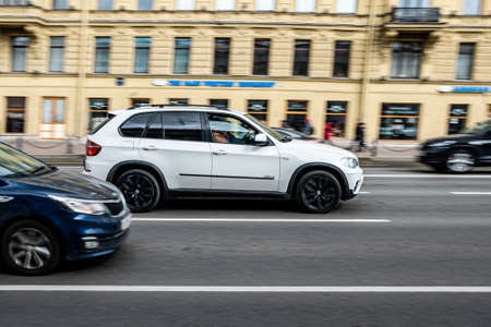 St. Petersburg, Russia, 03.05.2021: White crossover car on the street road. White BMW. Blurred background. Car motion.のeditorial素材