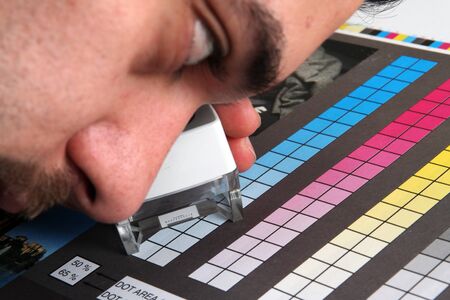 Prepress color menagement in print production. CMYK color check on printed paper. Quality printing conceptの写真素材