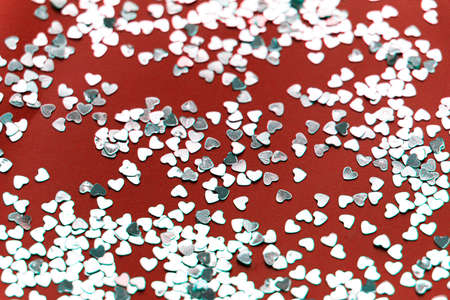 beautiful background, sparkles in the form of hearts on a red paper. perfect layout for holiday...
