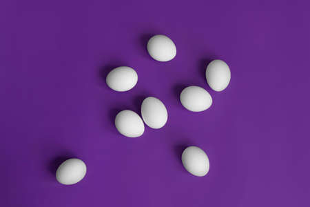 white eggs in a grid on a purple background postcard for easter minimalismの写真素材