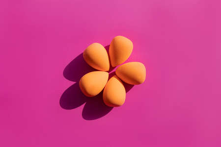 makeup sponges on a pink background with hard shadows from the sun. High quality photoの写真素材