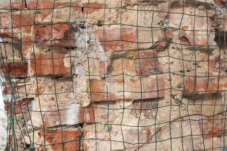 Wire mesh metal on old red brick wallの写真素材