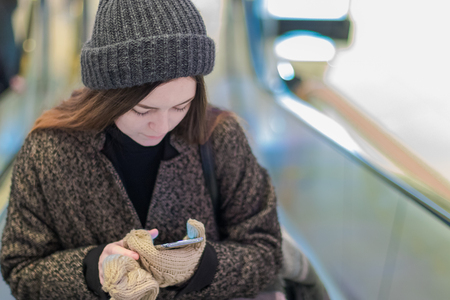 Beautiful girl in winter coats and knitted Hat on elevatorの写真素材