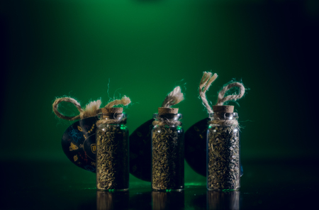 bottles with spices stand in the mirror surface on a green background.の写真素材