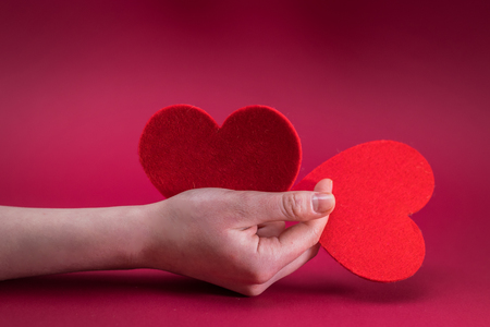 Valentines Day. Love heart. Female hands holding red two heart.の写真素材