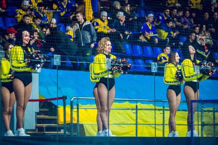 Kiev, Ukraine - December 17, 2019: ice hockey u20 world championship Ukraine - Ukraine VS Italy Group of cheerleaders in action with male coach - Concept of unity and team sport - Training at college high school with young female teenagers.のeditorial素材