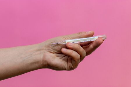 male hands holding a thermometer.の写真素材