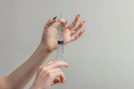 Syringe, medical injection in hand, palm or fingers. Medicine plastic vaccination equipment with...