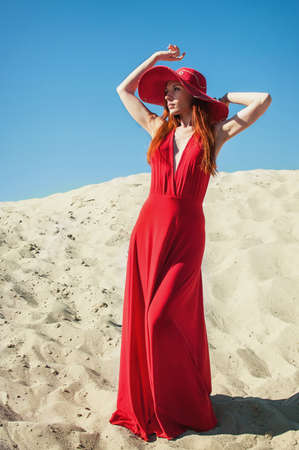 Happy Beautiful Woman in Red Dress on the Beachの写真素材